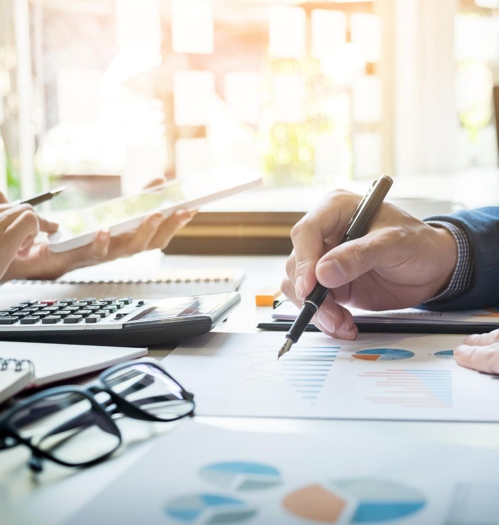 Photo of two people using calculators, pen and paper