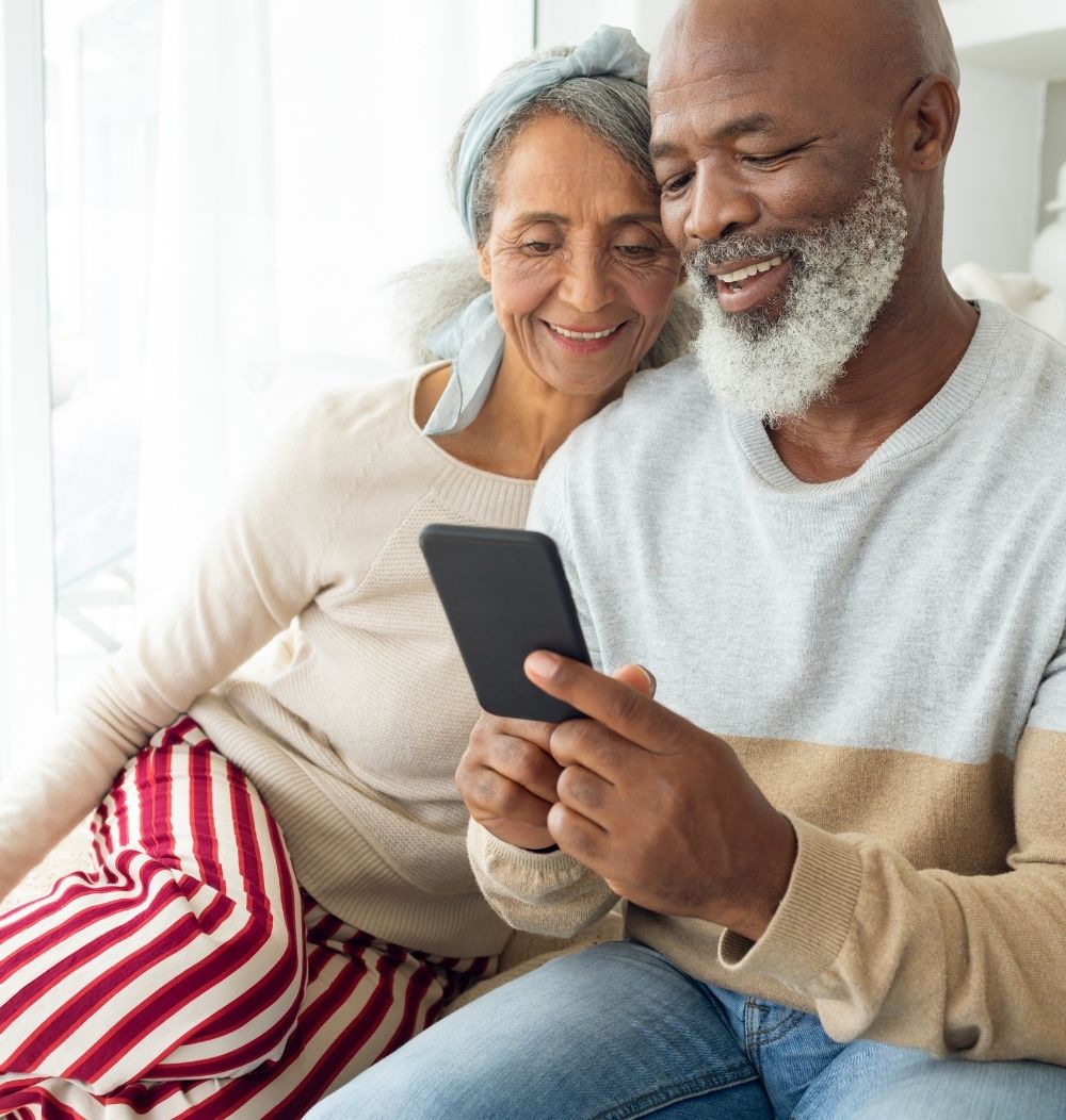 Photo of man and woman viewing a smartphone together