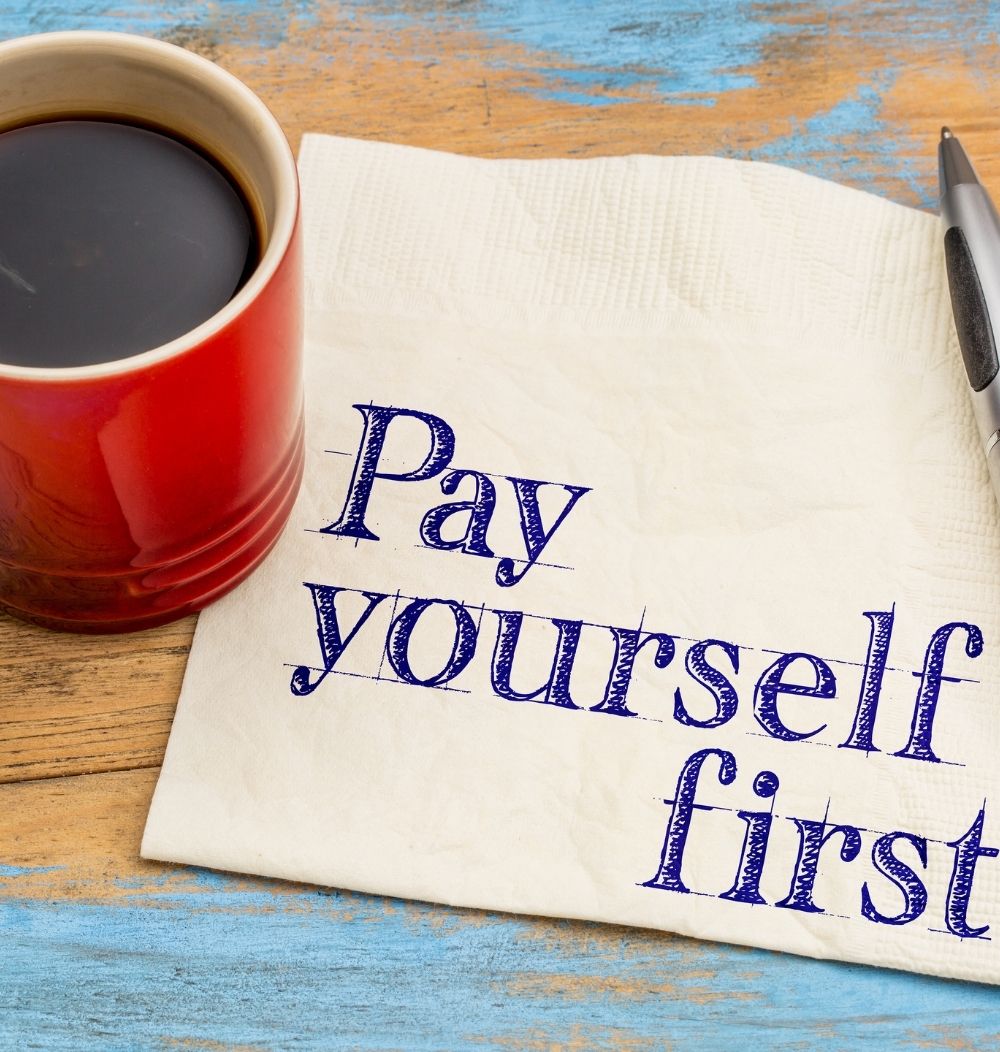Photo of cup of coffee and napkin with "Pay Yourself First" written on it