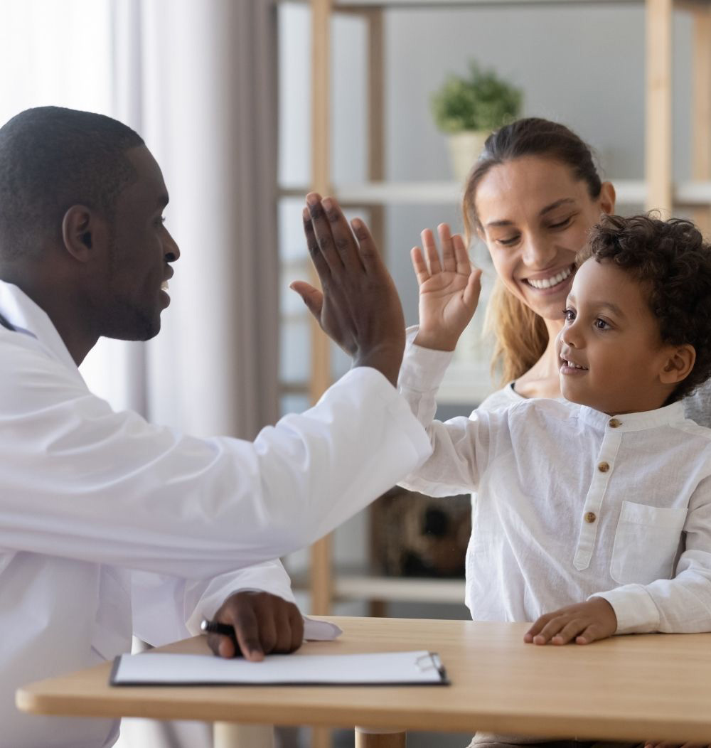 An image of a doctor high-fiving a young patient.