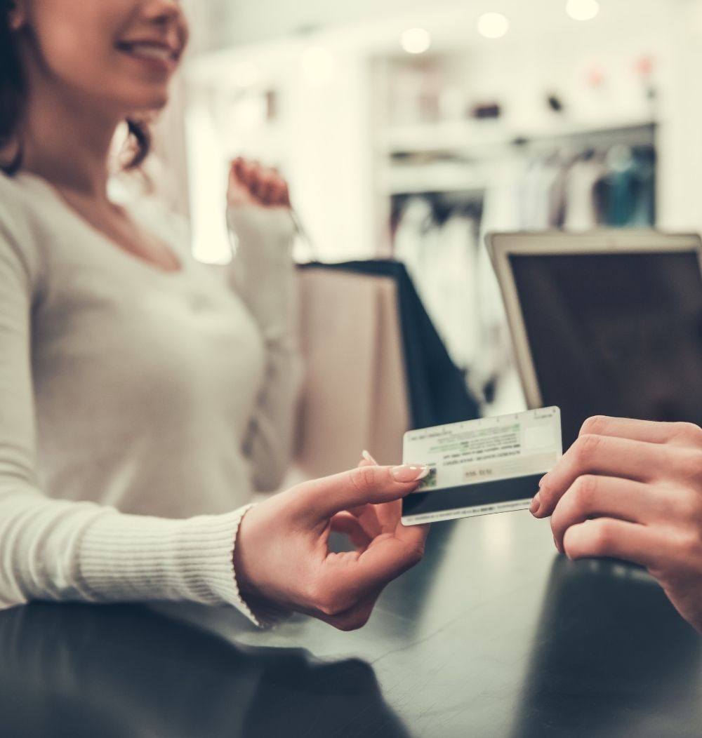 An image of a woman paying with debit or credit card.