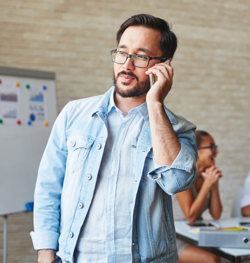 A business man, dressed casually, on the phone.