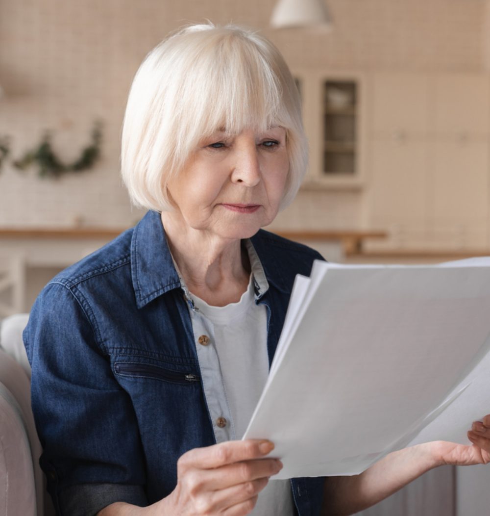 An image of an older woman looking over her finances.
